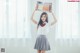 A woman in a school uniform holding up a book.