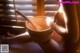 A naked woman sitting in a wooden bowl with a wooden spoon.