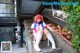 A woman in a pink and white outfit sitting on some steps.