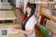 A young woman sitting at a desk in a library.