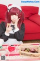 A woman sitting at a table with a basket of chocolates.