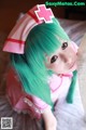 A woman with green hair wearing a pink nurse outfit.