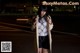 A woman standing in the middle of a street at night.