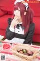 A woman sitting at a table eating a cookie.