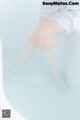 A woman sitting in a bathtub with her legs crossed.