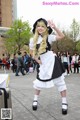 A woman dressed in a maid outfit posing for a picture.