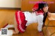 A woman in a red and white uniform is posing on the floor.