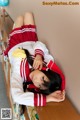 A woman in a school uniform laying on a desk.