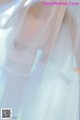 A mannequin wearing a white dress with a veil over it.