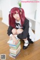 A woman sitting on top of a pile of books.