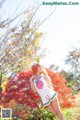 A woman in a sailor outfit posing in front of a tree.