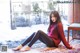 A woman sitting on a rug in the snow.