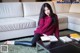 A woman sitting on the floor with a book and a coffee table.