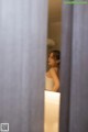 A woman standing in front of a mirror in a bathroom.