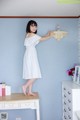 A woman in a white dress standing on a dresser.