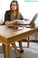 A woman sitting at a table with a laptop computer.