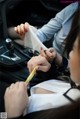 A woman sitting in a car holding a piece of paper.