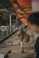 A woman walking down a flight of stairs with a suitcase.