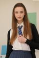 A young woman in a school uniform is posing for a picture.