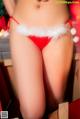 A woman in a red bikini with a santa hat on.