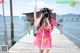 A woman taking a picture of herself on a pier.