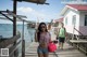 A woman standing on a wooden dock talking on a cell phone.