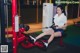 A woman is sitting on a bench in a gym.