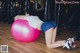 A woman laying on an exercise ball in a gym.