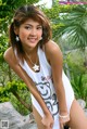 A woman in a white tank top posing for a picture.