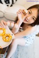 A young girl sitting on a couch eating donuts.