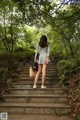 A woman is walking up some steps in the woods.