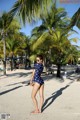 A woman in a polka dot swimsuit standing on a beach.