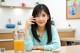 A woman sitting at a table with a glass of orange juice.