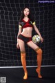 A woman in a soccer uniform holding a soccer ball.