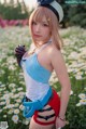 A woman in a blue and white outfit standing in a field of flowers.