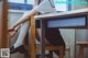 A woman sitting at a desk with her legs crossed.