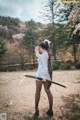 A woman in a white dress holding a sword.