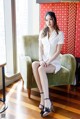 A woman sitting on a green chair in a room.