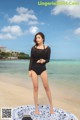 A woman standing on a beach next to the ocean.