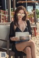 A woman sitting on a chair reading a newspaper.