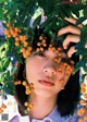 A woman with a bunch of orange berries on her head.