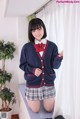 A young woman in a school uniform posing for a picture.