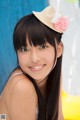 A young woman wearing a straw hat with a flower on it.