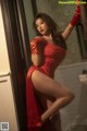 A woman in a red dress and red gloves posing in a bathroom.