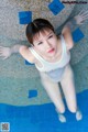 A woman in a white bathing suit standing in a pool.