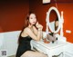 A woman sitting at a dressing table in front of a mirror.