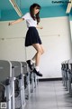 A young woman in a school uniform jumping in the air.