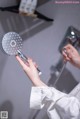 A woman is holding a shower head in her hand.