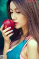 A woman holding a red apple in her hand.