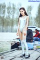 A woman in a silver bodysuit standing on a dock.